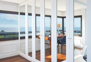 Enjoy a panoramic ocean view from this room's large window, featuring a desk for work or relaxation.