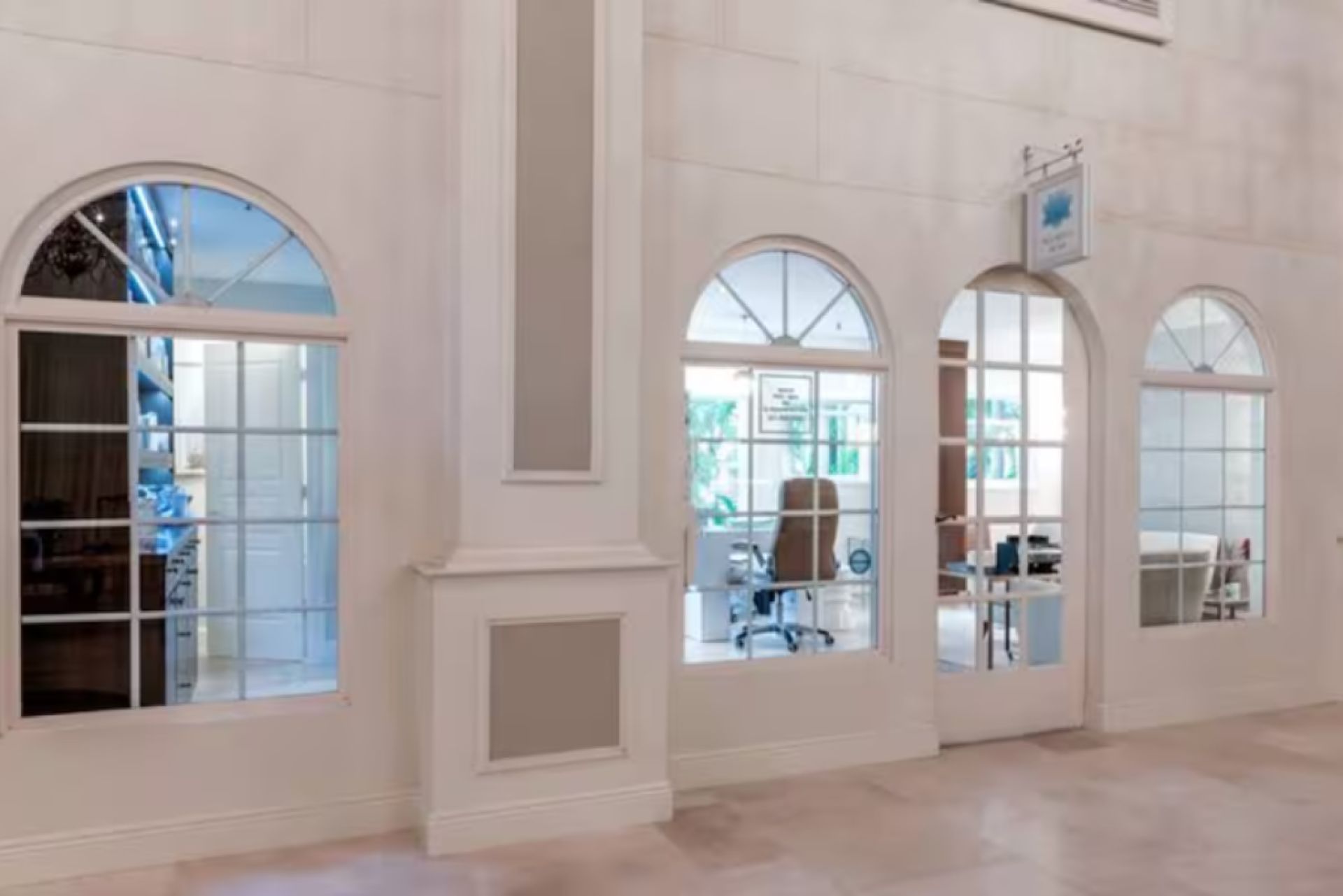 Un intérieur spacieux, doté de grandes fenêtres en arc de cercle, d’un plafond haut et d’un aménagement épuré et minimaliste.