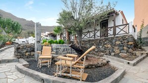 Un espace patio doté d’un sol en pierre, de mobilier d’extérieur et d’un mur en pierre.