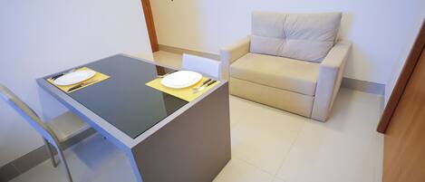 Una habitación pequeña y moderna con una mesa de comedor, un sofá y una silla.