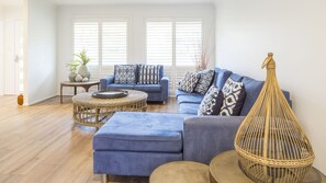 Relax in this stylish living room with a large sofa, wicker coffee table, and a unique wicker chair.