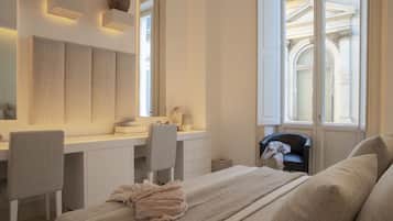 Un dormitorio con una cama, un escritorio y una silla. Hay una ventana con vista a un edificio.