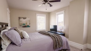 A bedroom with a bed, a ceiling fan, a TV, and two windows with blinds. - *5 Min to WVU*Smart TV*Full Kitchen*W/D (Morgantown)