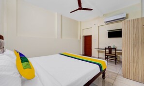 A hotel room with a bed, a desk, a chair, an air conditioning unit, and a wardrobe. - Itsy Hotels Green Villaa, 2 Km From Pondicherry Railway Station (Puducherry)