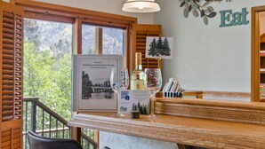 A wooden bar area with a framed welcome sign, a QR code, and a bottle of liquor.