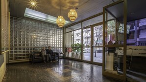 A modern interior with a brick floor, a glass wall with a grid pattern, and two hanging lamps. - 32-rustico Natural.2951 José (Ciudad Autónoma de Buenos Aires, Recoleta)