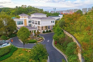 A multi-story building with a landscaped driveway and surrounding greenery.