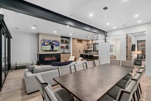 A modern living room with a large dining table, sofas, and a fireplace. - Canyons Ridge - Brand New Ski In Townhouse (Park City)