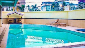 An indoor swimming pool with a shaded area and lounge chairs. - Impeccable Family Friendly Apartment in Nairobi (Nairobi)