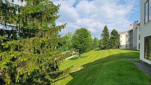 A modern building with a sloped roof, large windows, and a well-maintained lawn with trees. - Newly Renovated 2BR - walk to lift;  walk to Stratton Village; easy parking (Stratton)