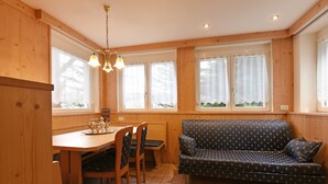 A wooden interior with a dining table, chairs, and a patterned sofa. - Top Located Alpin-Residence Amadeus*** Luxury Alpine GEM for 5 Pax (Seis)