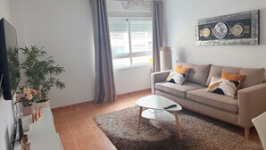 A living room with a sofa, coffee table, and a potted plant. - MODERN APARTMENT IN THE CENTER OF MARBELLA (Marbella)