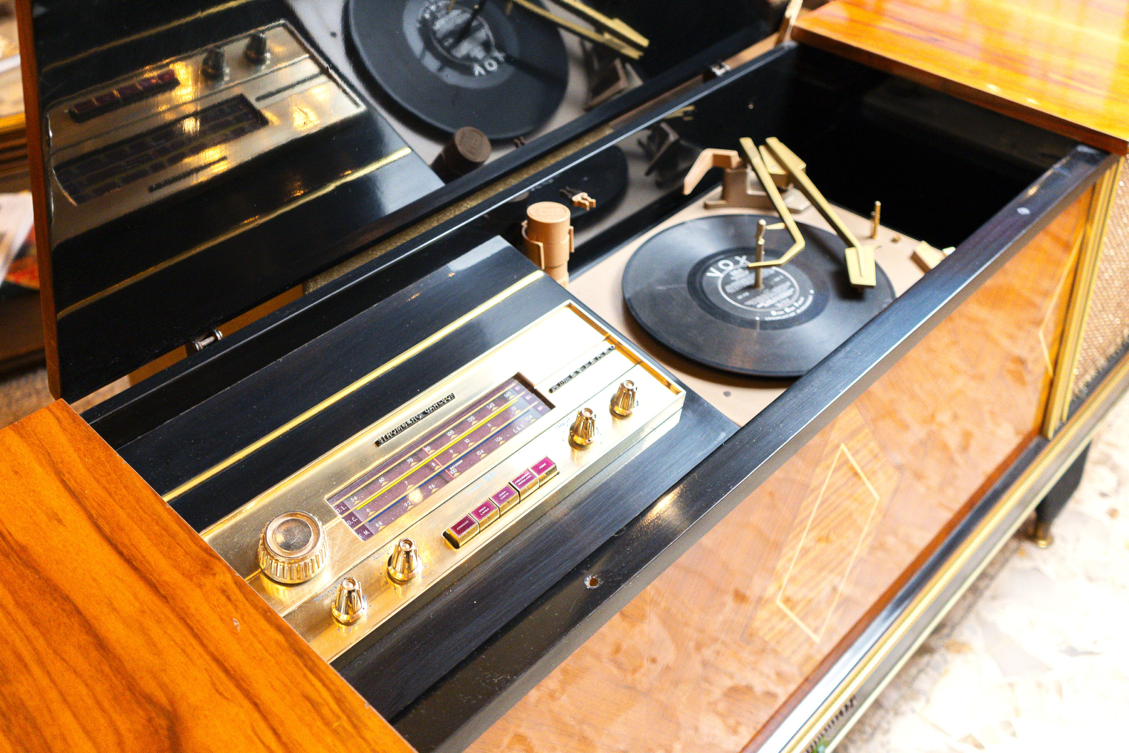 Um rádio antigo com estrutura de madeira e um toca-discos.