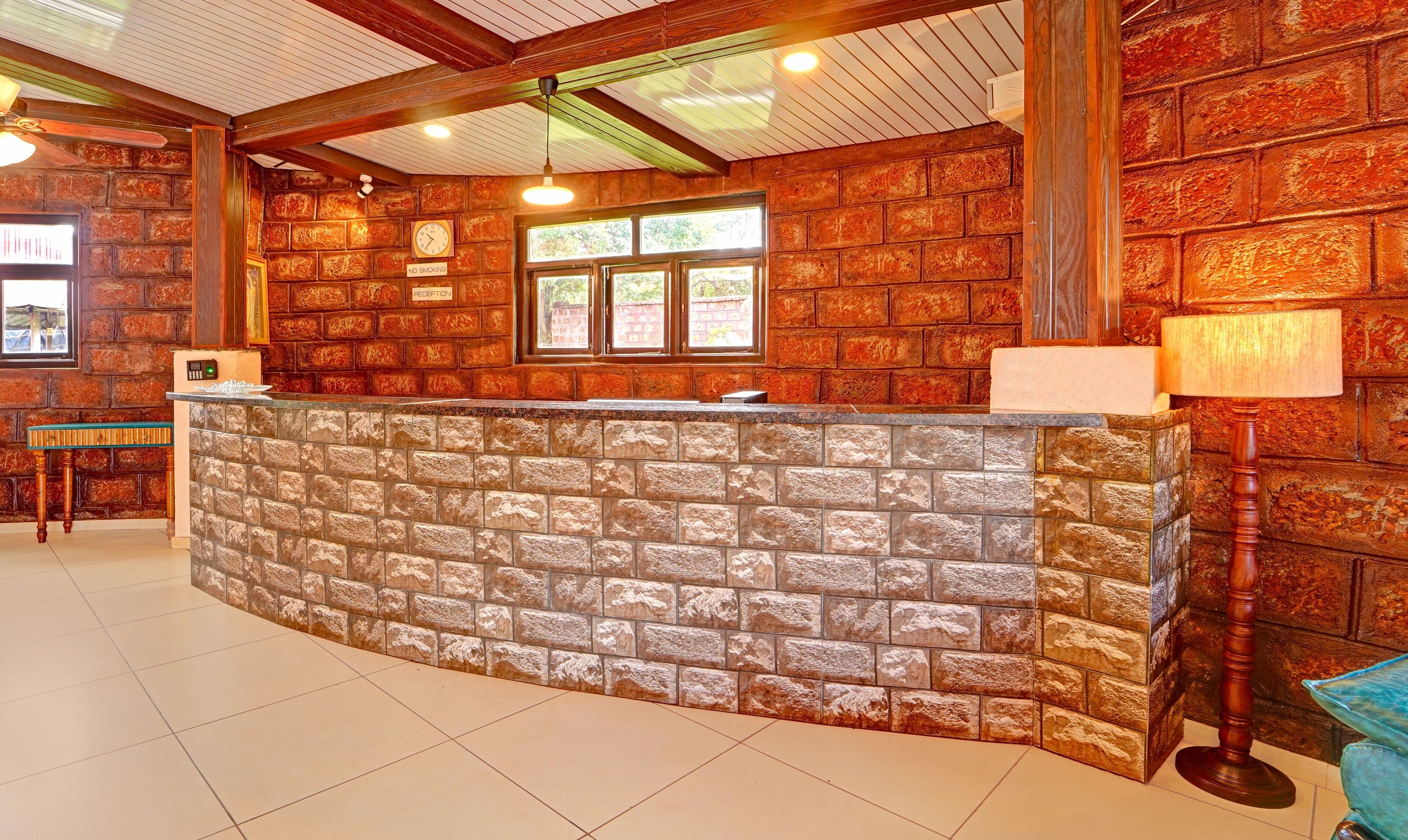 A reception area with a stone counter, wooden beams, and a 'No Smoking' sign.