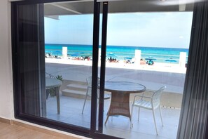 Uma varanda com vista para a praia e o oceano.