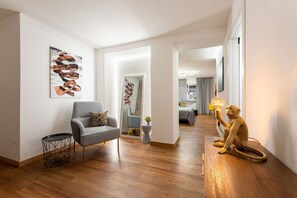 A modern living room with a checkered armchair, a small round table, and a monkey sculpture.