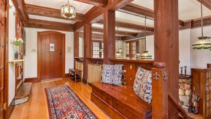 A wooden-floored hallway with a bench, a patterned rug, and a large mirror. - The Kirtland Cutter Rock House - Metaline Falls (Metaline Falls)