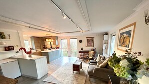 A spacious living area with a kitchen, a dining table, and a sofa. - Luxury Chilterns Hideaway, Easy Access to London (Reading)