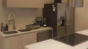 A modern kitchen with a stainless steel refrigerator, a coffee maker, and a dishwasher. - FRACCIONAMIENTO NAUTICO by TRVL2HM (Nuevo Nayarit)