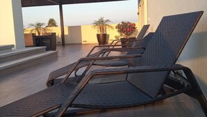 A rooftop terrace with four lounge chairs, a large potted plant, and a small table. - FRACCIONAMIENTO NAUTICO by TRVL2HM (Nuevo Nayarit)