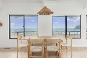 Enjoy meals with a view of the ocean from this dining area featuring a large table and six chairs.