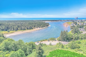 River winds through a forested area, lined with sandy and grassy terrain.