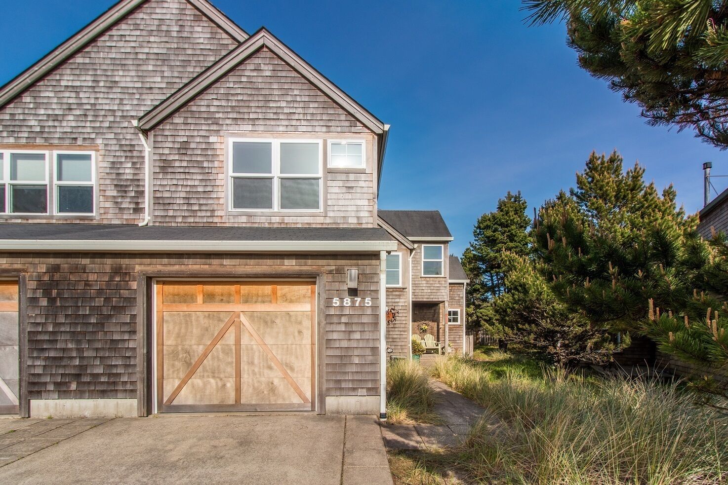 A two-story house with a garage, a visible address number, and a well-maintained lawn.