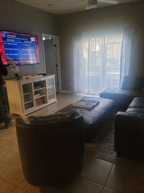A living room with a television displaying a sports report, a sofa, a coffee table, and a cabinet.
