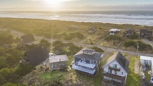 Un quartier résidentiel situé sur la côte, avec des maisons, une route et une vue sur l’océan.
