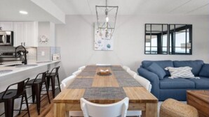 A modern kitchen with white cabinets, a built-in microwave, and a coffee machine.