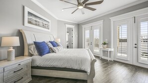 A bedroom with a bed, a nightstand, a ceiling fan, and a window with blinds.