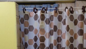 Ein Badezimmer mit gelben Wänden und einer Duschvorhang mit geometrischem Muster.