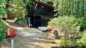 Une cabane dotée d’une terrasse en bois et bordée d’un petit ruisseau.
