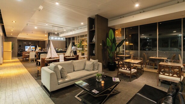 Un moderno vestíbulo de hotel con un sofá, una mesa de centro y un área de comedor.