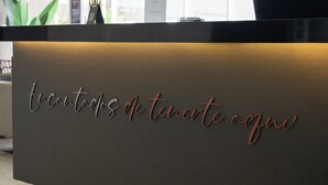 Una mesa de recepción con superficie texturizada y un letrero que dice 'Encantados de tenere a gui'.