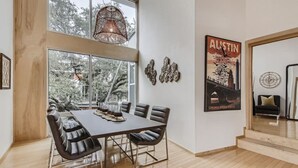 A dining area with a large table, chairs, and a hanging light fixture. - Spacious Retreat for Groups W/Workspace Min to DT & SXSW Top Spots! (Austin)