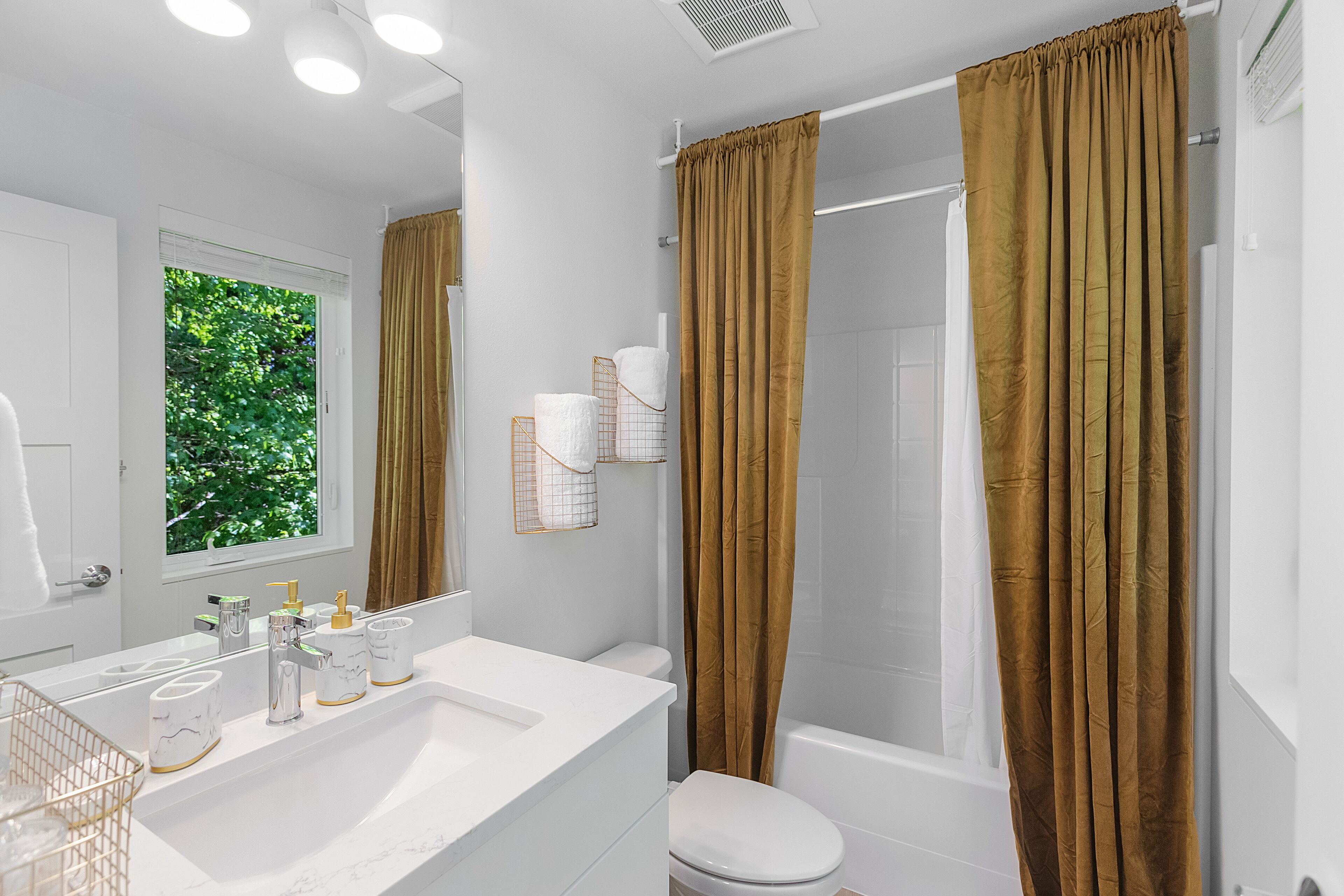 Un baño moderno con un lavamanos blanco, un inodoro y una zona de ducha.