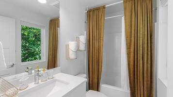 Un baño moderno con un lavamanos blanco, un inodoro y una zona de ducha.