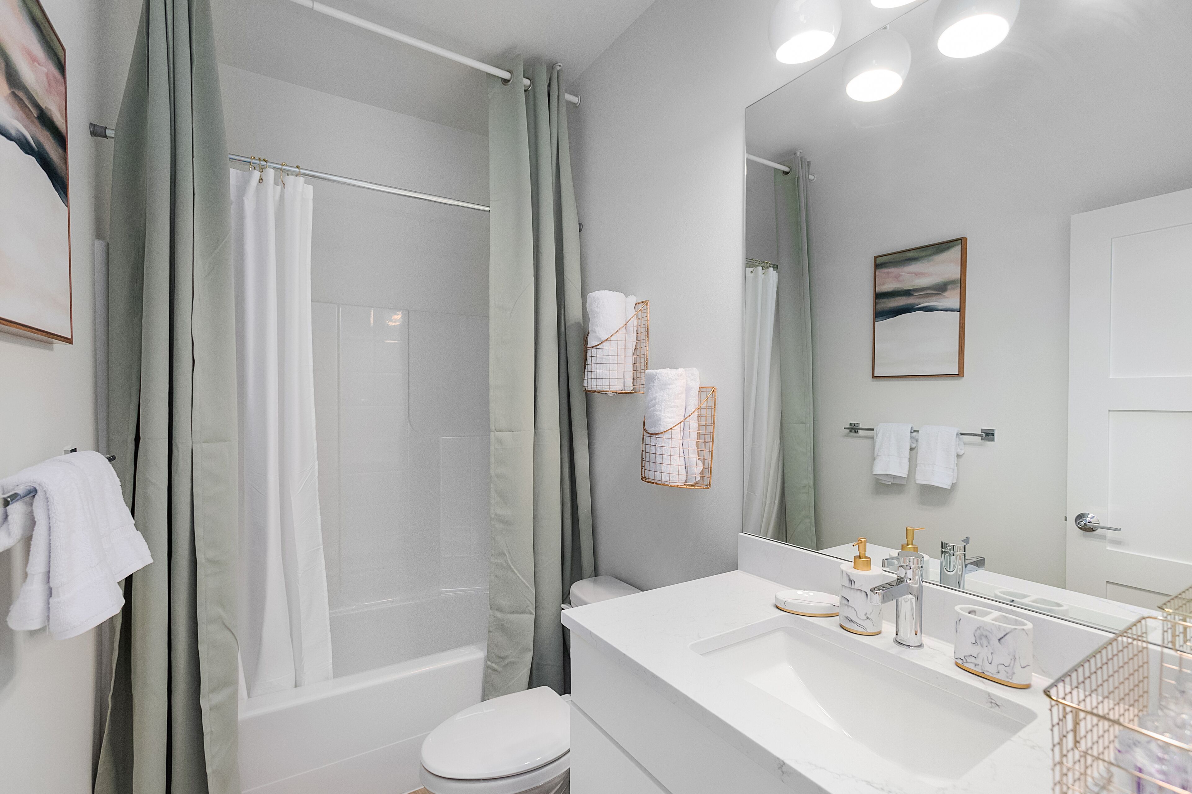 A modern bathroom with a shower, toilet, and sink.