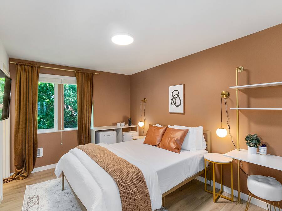 Una camera da letto moderna con un letto, un comodino, una scrivania e una sedia.
