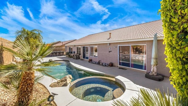 Ein Haus mit Schwimmbad, Terrasse und überdachter Außenausstattung.