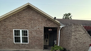 A brick building with a large window and a door. - Quiet and comfortable Two Bedrooms, one Bathroom up to group of Four. (Mission)