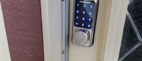 A door with a numeric keypad lock and a brass door handle.