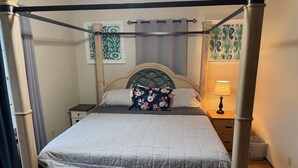 A four-poster canopy bed with a quilted mattress, a floral pillow, and a bedside lamp. - Quiet and comfortable Two Bedrooms, one Bathroom up to group of Four. (Mission)
