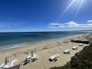 Ranta lähistöllä, aurinkotuoleja, rantapyyhkeitä