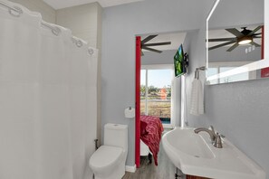 Een moderne badkamer met douche, toilet en wastafel.
