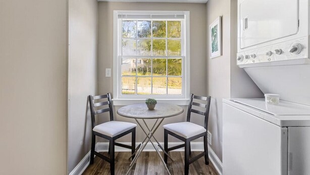A kitchen with a window, two chairs, a table, and a stove.