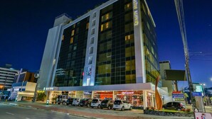 Een modern hotel met meerdere verdiepingen, grote ramen en een opvallend bord met 'Quality Suites'.