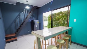 Una cocina moderna con una isla grande, taburetes de bar y un refrigerador.