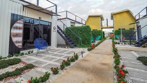 Un sendero que lleva a un edificio con una escalera y una silla azul.